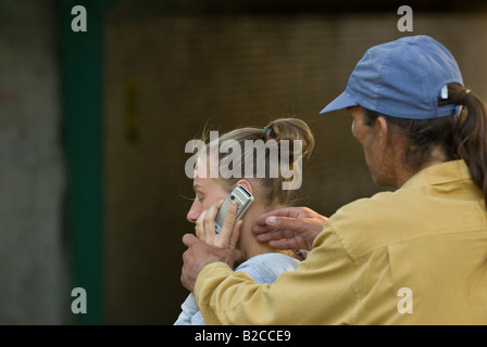 Weißen männlichen Angreifer Tassen junge weiße weibliche Opfer von ihrem Handy Stockfoto