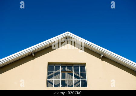 Teil von einem Holzdach mit Fenster als Detail eines Lagers vor blauem Himmelshintergrund Stockfoto