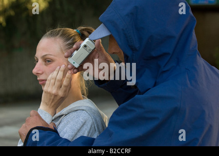 Weißen männlichen Angreifer Tassen junge weiße weibliche Opfer von ihrem Handy Stockfoto