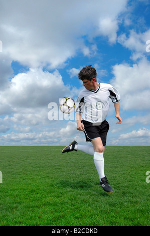 Fußball-Spieler bei einem Back Kick über einen bunten Hintergrund Stockfoto