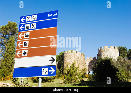Wegweiser mit blau weiße eine braune Teller zeigen Richtungen in der Nähe von einer mittelalterlichen Burg Portugal Stockfoto