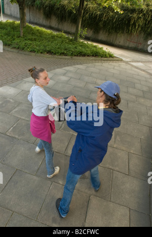 Weißen männlichen Angreifer Tassen junge weiße weibliche Opfer ihre Handtasche Stockfoto