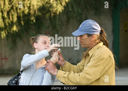 Weißen männlichen Angreifer Tassen junge weiße weibliche Opfer von ihrem Handy Stockfoto