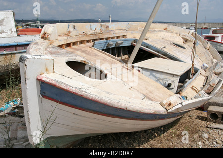 Ein altes Boot ruht auf dem Sand von einem kleinen Hafen Stockfoto
