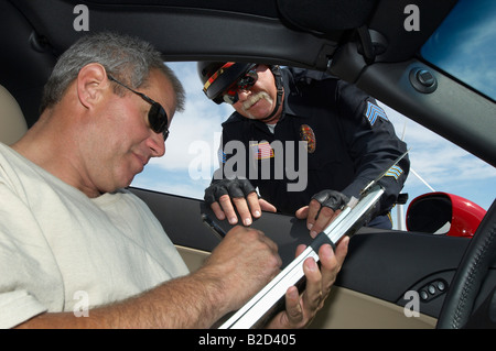 Polizist beobachtete Treibersignierung Papiere, Blick vom Auto Stockfoto