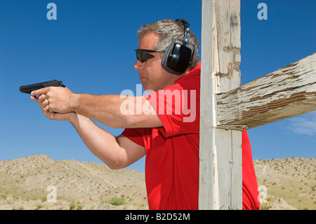 Mann mit dem Ziel Handfeuerwaffe am Schießplatz Stockfoto