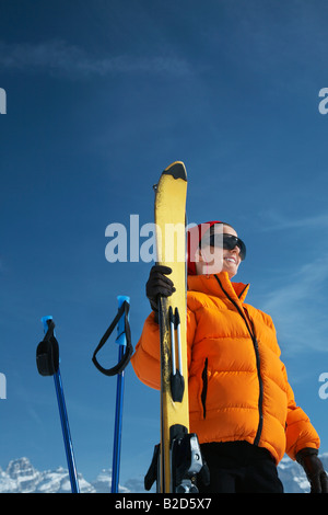 Von Ski und Skistöcke lächelnde Frau Stockfoto