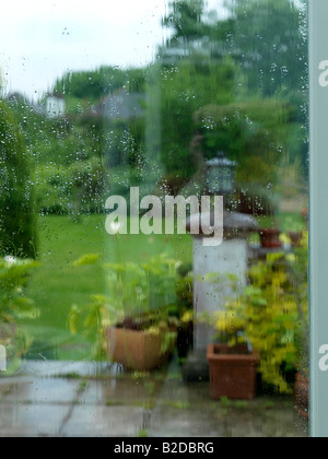 Regen in den Garten und die Regentropfen auf das Fenster Stockfoto