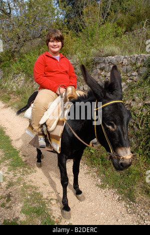 junges Mädchen Reiten eines Esels, in der Nähe von Campell, Marina Alta, Provinz Alicante, Comunidad Valenciana, Spanien Stockfoto