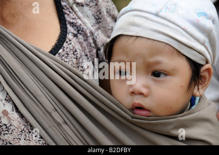 Nahaufnahme des Gesichts eines Baby-jungen in einer Schlinge Zentrales Hochland Vietnam durchgeführt werden Stockfoto