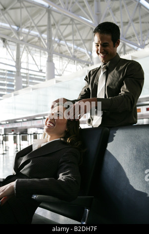 Junger Mann geben Geschäftsfrau Kopfmassage im Flughafen. Stockfoto