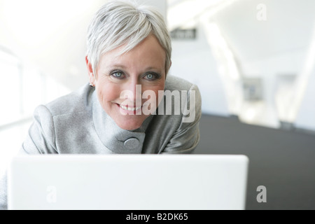 Glücklich Reife Frau mit Laptop im Flughafen. Stockfoto