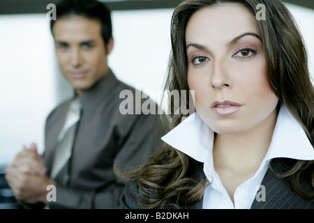 Porträt der Geschäftsfrau im Flughafen mit Geschäftsmann hinter. Stockfoto
