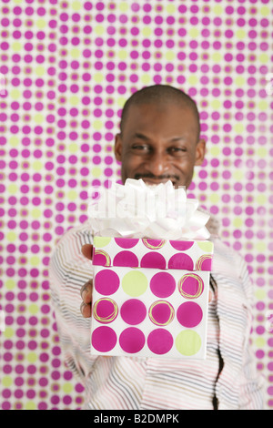 Afrikanische amerikanische Mann, hält Geburtstagsgeschenk. Stockfoto