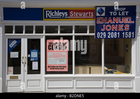 Closed Shop mit Plakaten im Fenster und für Verkauf Zeichen plus beachten Sie, dass Unternehmen in Konkurs Brecon Stadtzentrum Wales UK Stockfoto