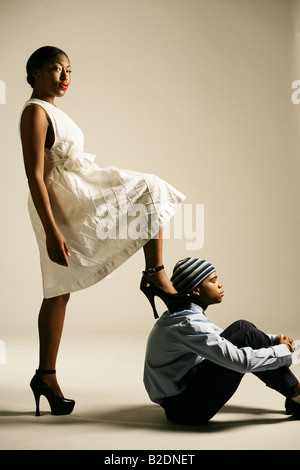 Young African American Woman verstärkt auf Mann, Studio gedreht. Stockfoto