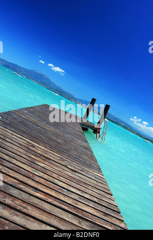 Kleiner Steg führt in unglaublichen grünen Wasser und blauer Himmel genommen am Gardasee Italien-perfekt für jede Art von Konzept für v Stockfoto