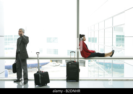 Geschäftsmann und Afro-Amerikaner Frau wartet am Flughafen. Stockfoto