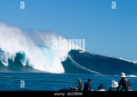 Mit einem auf Wasser nimmt Zuschauer ein Schlepp-Surfer links auf Hawaiis big Surfspot Peahi (Backen) aus Maui. Stockfoto