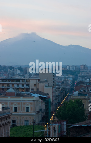 Am Abend Schlummer. Den Ätna bei Sonnenuntergang mit Catania Gebäude leuchtet Augenzwinkern auf entlang der Straßen der Stadt, die Vögel in Kraft sind. Stockfoto