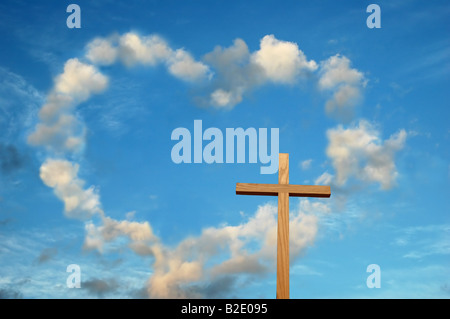 Hölzernes Kreuz und Herz geformten Wolken im Hintergrund Stockfoto