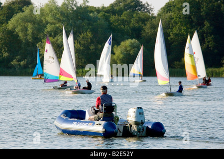 Segellehrer und Jugendliche in ihren Yachten während Segeln Schule, Lackford Seen, Suffolk, England Stockfoto