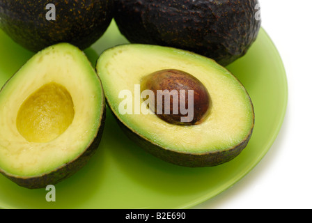 Zwei Avocados eine in Scheiben geschnitten in der Hälfte, Samen ausgesetzt Stockfoto