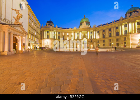 Schloss und Kirche beleuchtet in der Abenddämmerung Michaeler Platz St.-Michaels-Kirche Hofburg Imperial Palace Vienna Austria Stockfoto