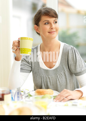 Junge Frau frühstücken und lächelnd Stockfoto