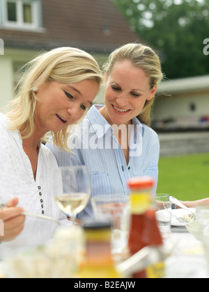 Nahaufnahme von zwei Frauen Lächeln am Tisch Stockfoto