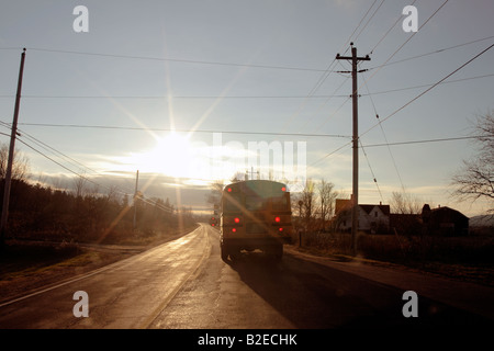 ein Schulbus auf der Autobahn mit einer verhüllenden Sonne Stockfoto