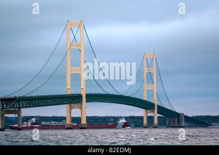 Ein Lastkahn vorbei unter die Mackinac Bridge in der Meerenge von Mackinac Mackinaw City Michigan Stockfoto