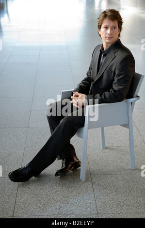Geschäftsmann in einem Sessel sitzend Stockfoto