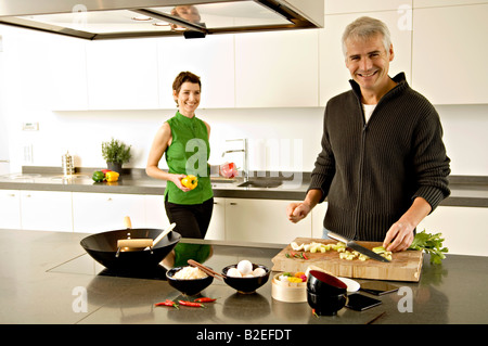 Porträt von einem reifen Mann und eine Mitte Erwachsene Frau, die Zubereitung von Speisen in der Küche Stockfoto