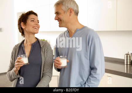 Reifer Mann und einer Mitte erwachsenen Frau Gläser Milch Stockfoto