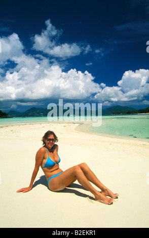 Frau im Bikini am Strand sitzen Stockfoto