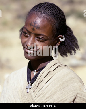 Eine Tigray-Frau hat ein Kreuz von der äthiopisch-orthodoxen Kirche auf der Stirn tätowiert, während zwei silberne Kreuze an den Hals hängen. Stockfoto