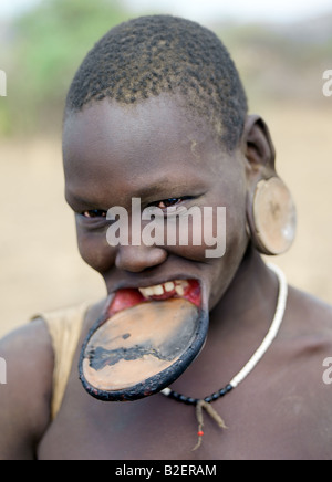 Eine Mursi-Frau trägt eine großen Ton Lippe Platte und Ohr Ornamente zu entsprechen. Stockfoto