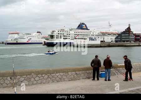 Hafen von Calais Frankreich Europa Männer Angeln an einem dumpfen bewölkten Tag Stockfoto