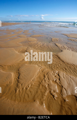 Wellen im Sand bei Ebbe auf einem der idyllischen Strände an der Küste von Mosambik Stockfoto