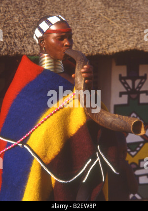 Ndebele-Frau in traditioneller Kleidung auf Kudu Horn geblasen Stockfoto
