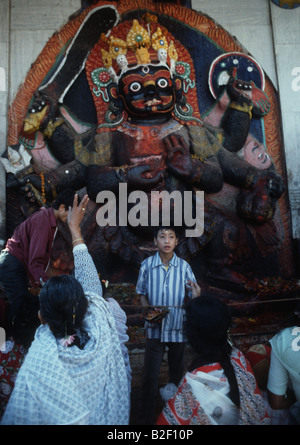 Hinduistischen Anbeter geben Angebote auf die Statue des Kala Bhairab die schwarzen Shiva der Zerstörer in Kathmandu Stockfoto