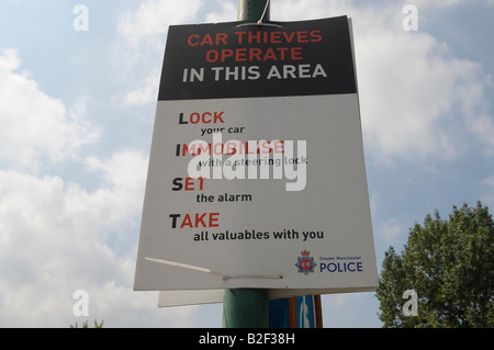 Autodiebe arbeiten in diesem Bereich-Plakat, das Zeichen, dass Manchester Polizei sperren Sie Ihr Auto mit einer Sperre Lenkvorrichtung immobilise alarm Stockfoto