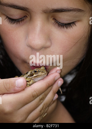 Junge Mädchen küssen ein Grasfrosch Stockfoto
