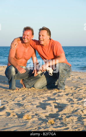 Ein glückliches Homosexuell Paar haben Spaß am Strand zusammen während ihrer Sommerferien. Stockfoto