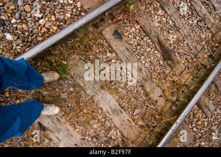 Nahaufnahme von einem Mann s Beine und Füße steht er auf einer Eisenbahn Spur Modell veröffentlicht Stockfoto
