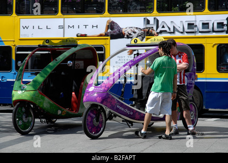 Youngs Mens Fahrer von Eco-Taxis in O' Connell Street, Dublin, Irland Stockfoto