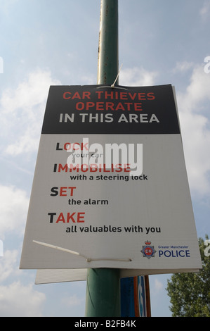 Autodiebe arbeiten in diesem Bereich-Plakat, das Zeichen, dass Manchester Polizei sperren Sie Ihr Auto mit einer Sperre Lenkvorrichtung immobilise alarm Stockfoto