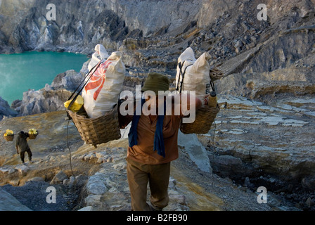 Aktivität im Ijen Krater; Arbeiter des Schwefel-Mine im Ijen Krater bei Tageslicht Stockfoto