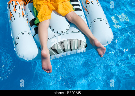 kleiner Junge Handauflegen aufblasbares Spielzeug im Schwimmbad Stockfoto